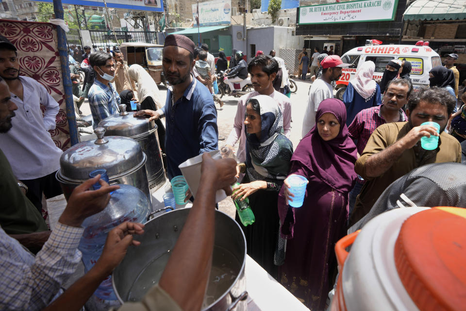 Volunteers provide lime sugar water to people at a camp set up to prevent heat stroke on a hot summer day, in Karachi, Pakistan, Thursday, May 23, 2024. Doctors were treating hundreds of victims of heatstroke at various hospitals across Pakistan on Thursday after an intense spell of the heat wave began in the country, and the mercury rose to above normal due to climate change, officials said. (AP Photo/Fareed Khan)