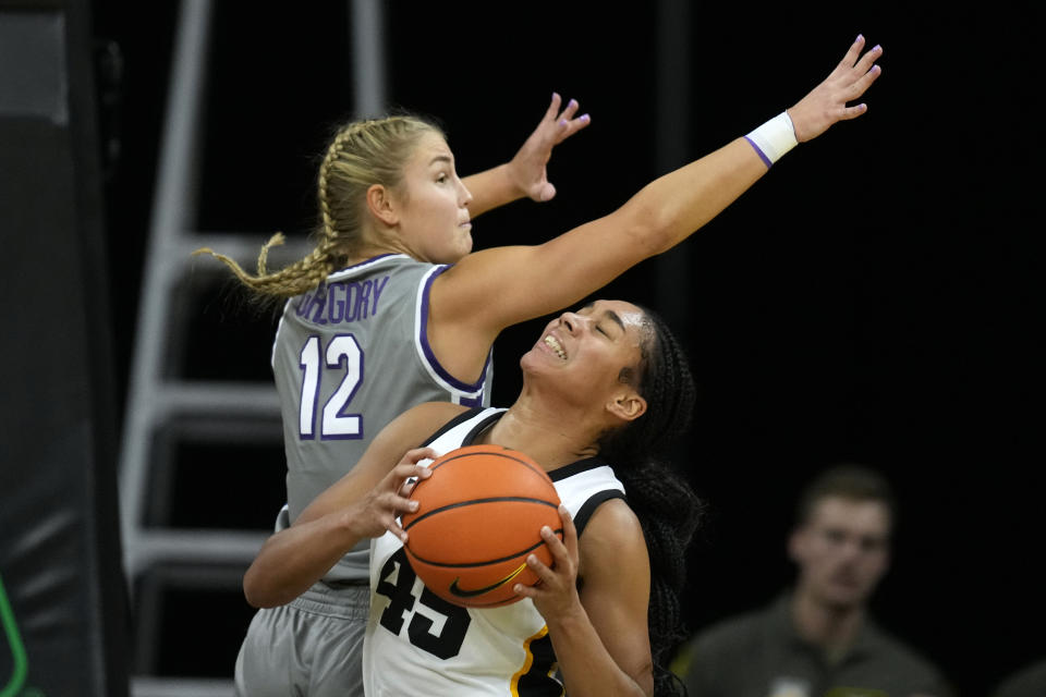 Iowa forward Hannah Stuelke (45) drives around Kansas State guard Gabby Gregory (12) during the first half of an NCAA college basketball game, Thursday, Nov. 16, 2023, in Iowa City, Iowa. (AP Photo/Charlie Neibergall)