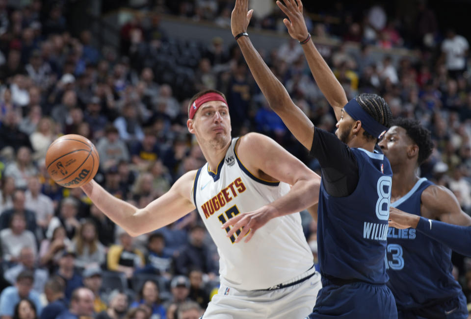 FILE - Denver Nuggets center Nikola Jokic looks to pass the ball as Memphis Grizzlies guard Ziaire Williams, front, and forward Jaren Jackson Jr. defend during the first half of an NBA basketball game April 7, 2022, in Denver. Jokic and the Nuggets agreed Thursday, June 30, to a $264 supermax extension, according to a person with direct knowledge of the negotiations who spoke to The Associated Press on condition of anonymity because neither the player nor team announced the agreement. (AP Photo/David Zalubowski, File)