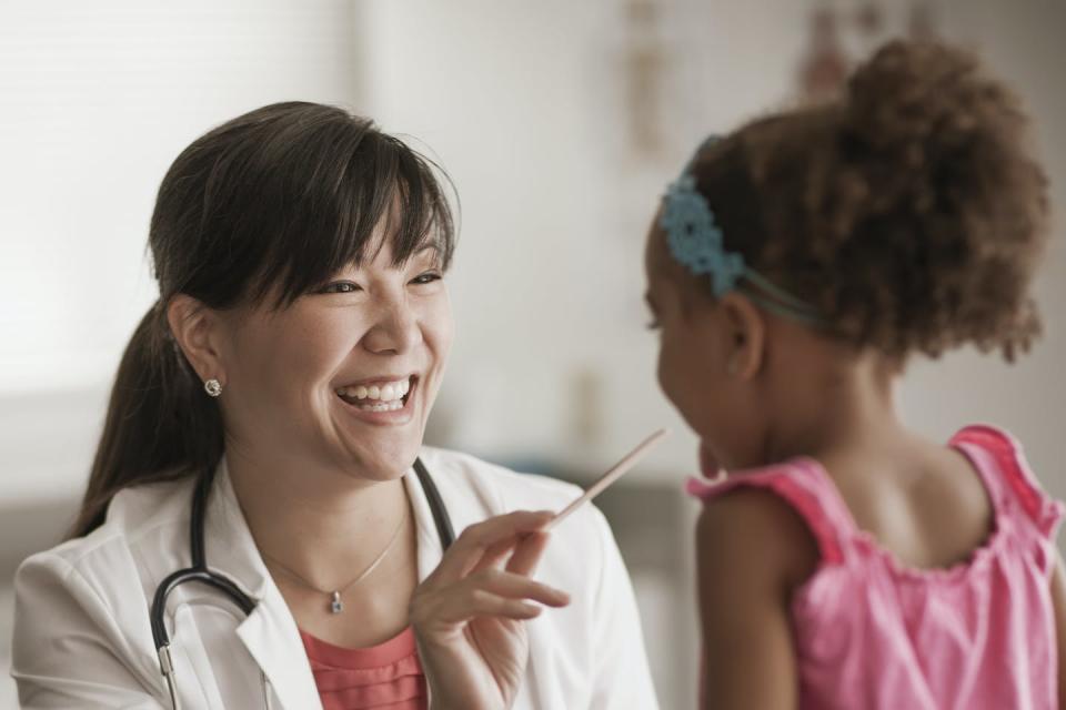 Healthcare provider examining child in exam room.