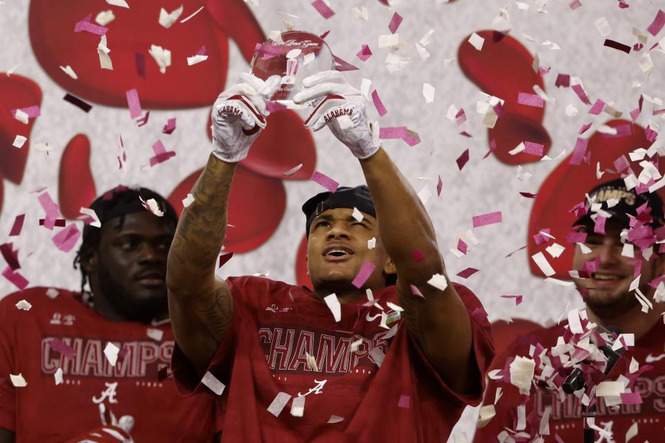 Alabama wide receiver DeVonta Smith holds up his most outstanding offensive player trophy after their 31-14 win against Notre Dame in the Rose Bowl NCAA college football game in Arlington, Texas, Friday, Jan. 1, 2021. (AP Photo/Ron Jenkins)