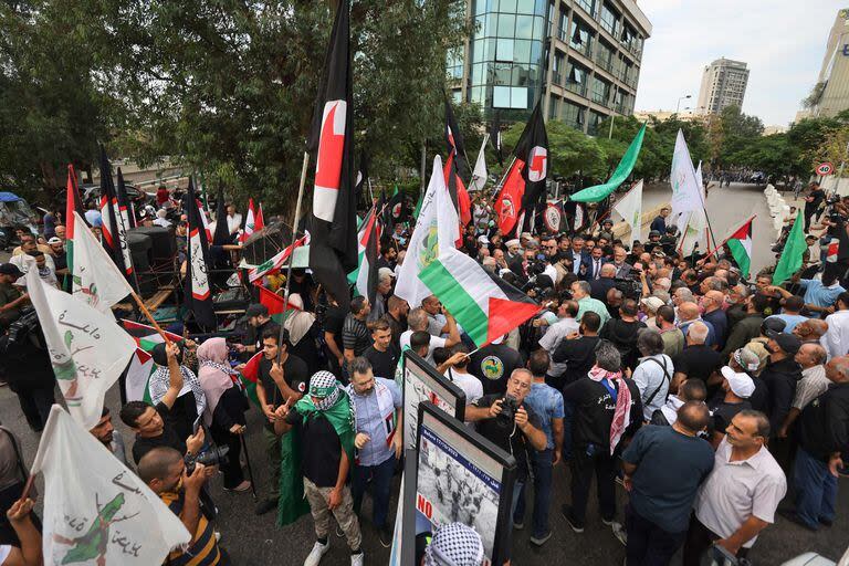 La gente levanta banderas durante una protesta cerca de la Embajada de Francia en Beirut, el 31 de octubre de 2023, en apoyo a los palestinos en Gaza en medio del conflicto en curso entre Israel y el movimiento Hamás.