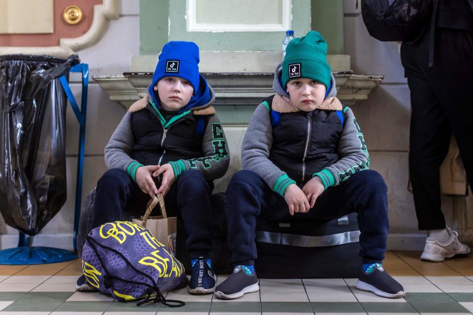 TOPSHOT - 6 years-old twins Artur (L) and Dawid from Odessa are seen waiting at the railway station in Przemysl, southeastern Poland, on April 6, 2022. - UNHCR, the UN refugee agency, said 4,278,789 Ukrainians had fled across the borders since the war began on February 24 -- a figure up 34,194 since April 5. (Photo by Wojtek RADWANSKI / AFP) (Photo by WOJTEK RADWANSKI/AFP via Getty Images)