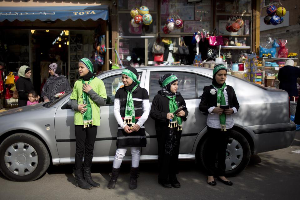 Israeli Arab girls look for passing cars to hand out Muslims prayer books in the main street in the Arab town of Taybeh, central Israel, Thursday, Jan. 9, 2014. A new proposal by Israel's powerful and outspoken foreign minister has sparked outrage among the country's Arab minority and added new complications to U.S. Secretary of State John Kerry's long shot Mideast peace mission. Avigdor Lieberman, the prime minister's top political ally, says he will oppose any peace plan that doesn't redraw Israel's borders to move large chunks of Israeli Arabs into a future Palestine. While the idea faces many obstacles, it has already managed to enrage Israeli Arabs who see it as another reminder of their second-class status in the Jewish state and a rejection of their national identity and bond to Palestinians living in the West Bank and beyond. (AP Photo/Ariel Schalit)