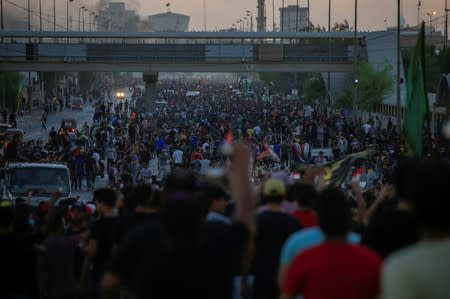 Demonstrators gather at a protest during a curfew, three days after the nationwide anti-government protests turned violent, in Baghdad