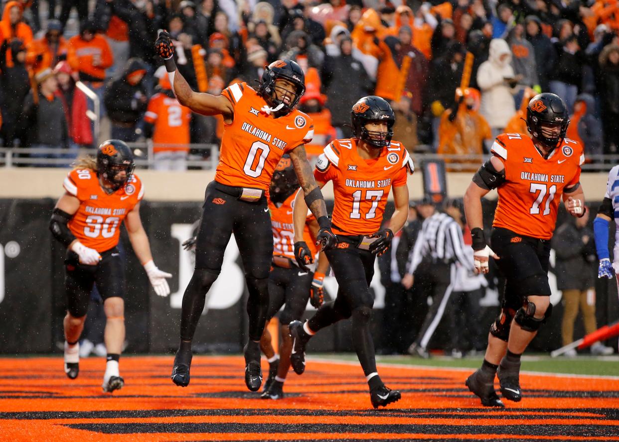 Nov 25, 2023; Stillwater, Oklahoma, USA; Oklahoma State's Ollie Gordon II (0) celebrates a touchdown during second half of the college football game between the Oklahoma State University Cowboys and the Brigham Young Cougars at Boone Pickens Stadium. Mandatory Credit: Sarah Phipps-USA TODAY Sports