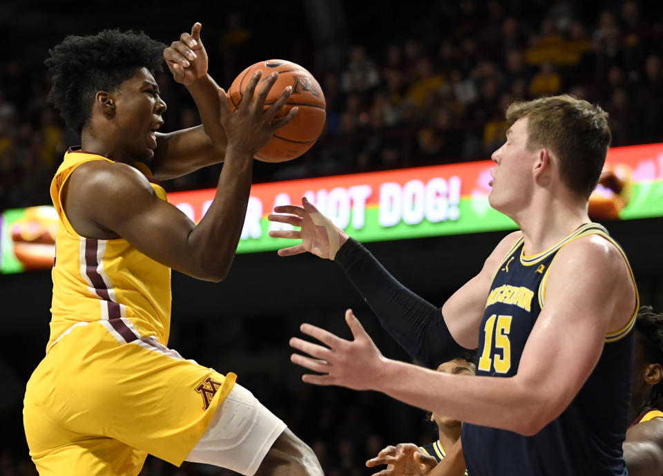 Minnesota's Marcus Carr, left, loses the ball against Michigan's Jon Teske (15) in the first half during an NCAA college basketball game on Sunday, Jan. 12, 2020, in Minneapolis. (AP Photo/Hannah Foslien)