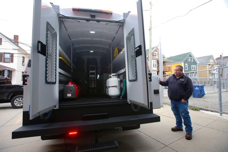 Brian Nobrega, Jr., Director of Emergency Management, opens various compartments of the new special operations vehicle the department has acquired.