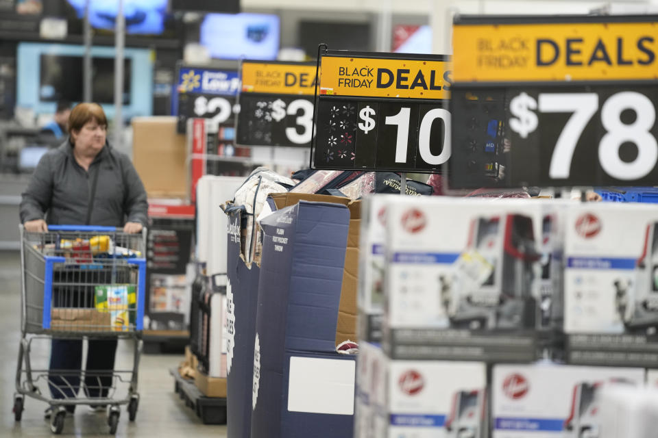 FILE - Signs advertise Black Friday deals at a Walmart in Secaucus, N.J., Nov. 22, 2022. According to the December Associated Press-NORC Center for Public Affairs Research poll, Republicans and Democrats have distinct views of what’s most important for the government to address amid high inflation. More Republicans name gas and food prices, energy and immigration; more Democrats focus on health care, climate change and poverty. (AP Photo/Seth Wenig, File)