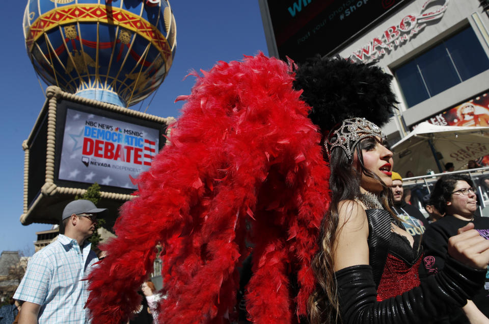 FILE - In this Feb. 19, 2020, file photo, people dressed as showgirls walk near the Paris Las Vegas hotel casino, site of a Democratic presidential debate, in Las Vegas. If Nevada has one job in the Democratic primary, it's to offer something different. And in many ways it has delivered. As the presidential race turned to the state this week, gone was the earnestness of Iowa and tradition of New Hampshire and in its place was racial diversity, a new unpredictability and the muscle of urban, union politics. (AP Photo/John Locher, File)