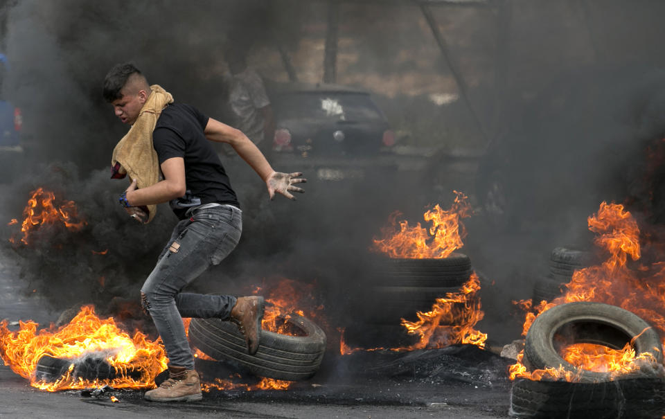 <p>Palestinians protesters are seen during clashes with Israeli security forces after a protest marking Nakba, or “catastrophe”, commemorating the more than 700,000 Palestinians who fled or were expelled in the 1948 war surrounding Israel’s creation, and against the US’ relocation of its embassy from Tel Aviv to Jerusalem, at the Hawara checkpoint south of Nablus on May 15, 2018. (Photo: Jaafar Ashtiyeh/ AFP/Getty Images) </p>