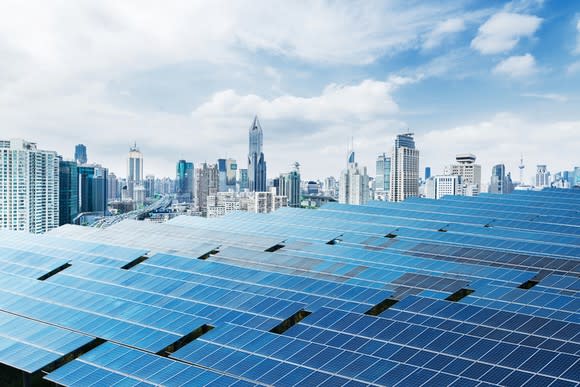 Solar panels with a city in the background.