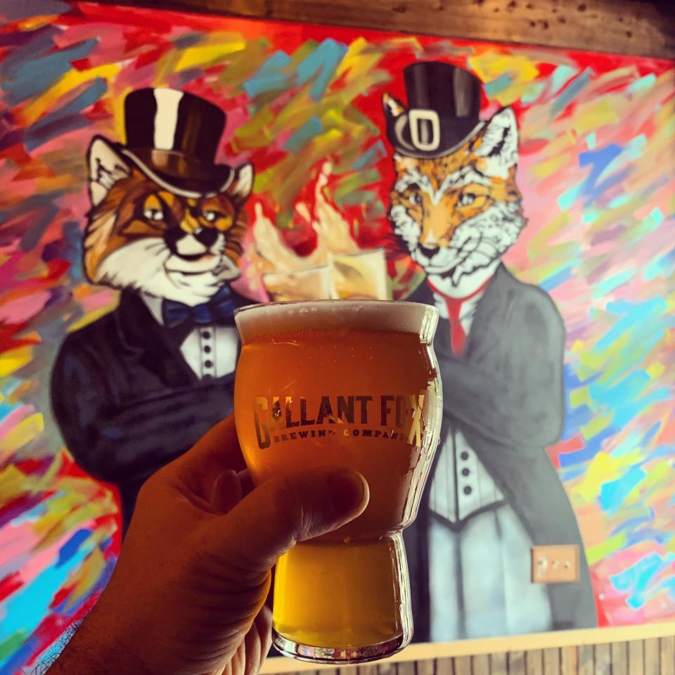 Starfox IPA at Gallatn Fox with tap room mural in the background.  Mural done by local artist Kacey Jackson.