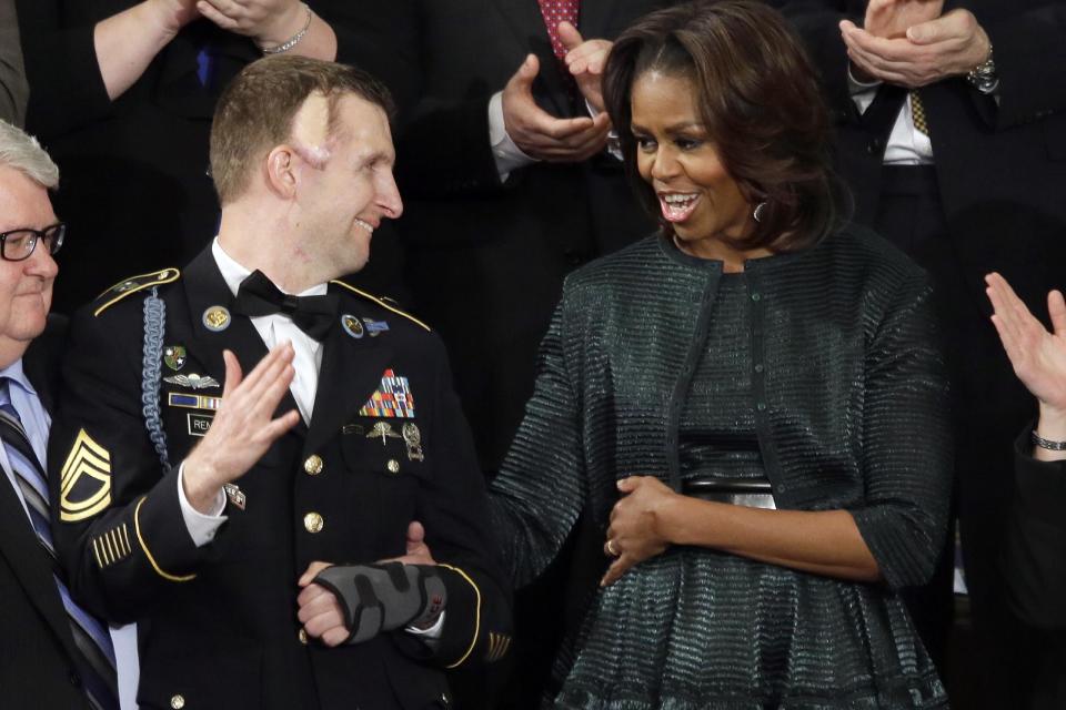 First lady Michelle Obama talks with Army Ranger Sgt. 1st Class Cory Remsburg during President Barack Obama's State of the Union address on Capitol Hill in Washington, Tuesday Jan. 28, 2014. (AP Photo/J. Scott Applewhite)