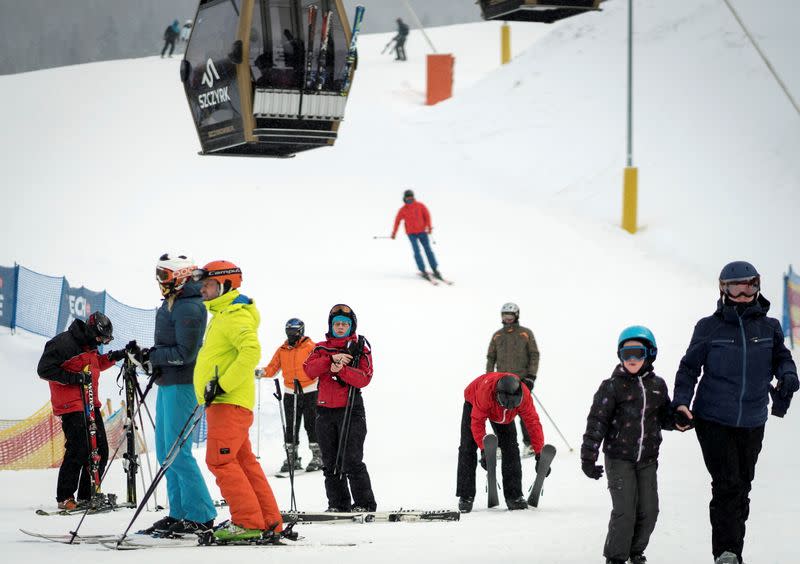 Skiers hold skis as they enjoy first day after loosening coronavirus disease (COVID-19) restrictions at ski slope in Szczyrk