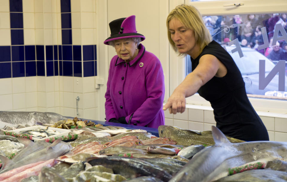 Queen Elizabeth II is shown some of the fish by shop manager Kerry Biggerstaff as she visits Newhaven Fish Market, West Quay Fisheries on October 31, 2013 in Newhaven, East Sussex, England.  (Photo by Arthur Edwards - WPA Pool/Getty Images)