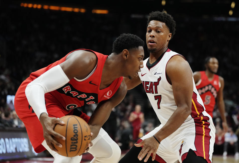 Toronto Raptors guard RJ Barrett (9) protects the ball from Miami Heat guard Kyle Lowry (7) during the first half of an NBA basketball game Wednesday, Jan. 17, 2024, in Toronto. (Frank Gunn/The Canadian Press via AP)