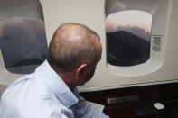 Turkey's President Recep Tayyip Erdogan watches from his plane the wildfires in Marmaris, Mugla, Turkey, Saturday, July 31, 2021. Panicked tourists in Turkey hurried to the seashore to wait for rescue boats Saturday after being told to evacuate some hotels in the Aegean resort of Bodrum due to the dangers posed by nearby wildfires, Turkish media reported. The death toll from wildfires raging in Turkey's Mediterranean towns rose to six Saturday after two forest workers were killed, the country's health minister said.(Turkish Presidency via AP, Pool)