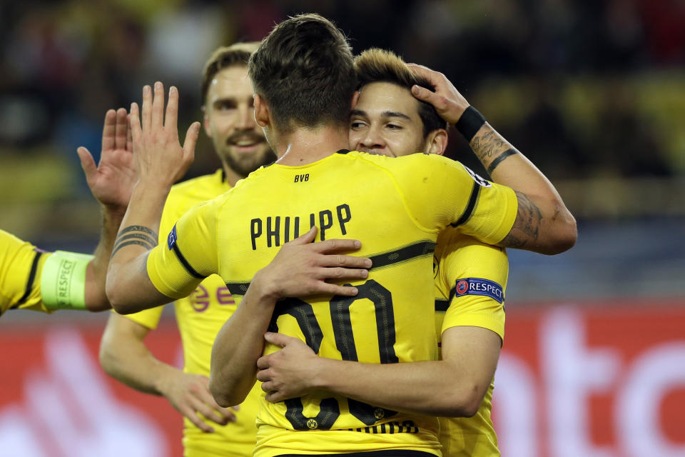 Dortmund's Raphael Guerreiro, right, celebrates with teammate Maximilian Philipp after scoring his side first goal during the Champions League group A soccer match between AS Monaco and Borussia Dortmund, in Monaco, Tuesday, Dec. 11, 2018. (AP Photo/Claude Paris)