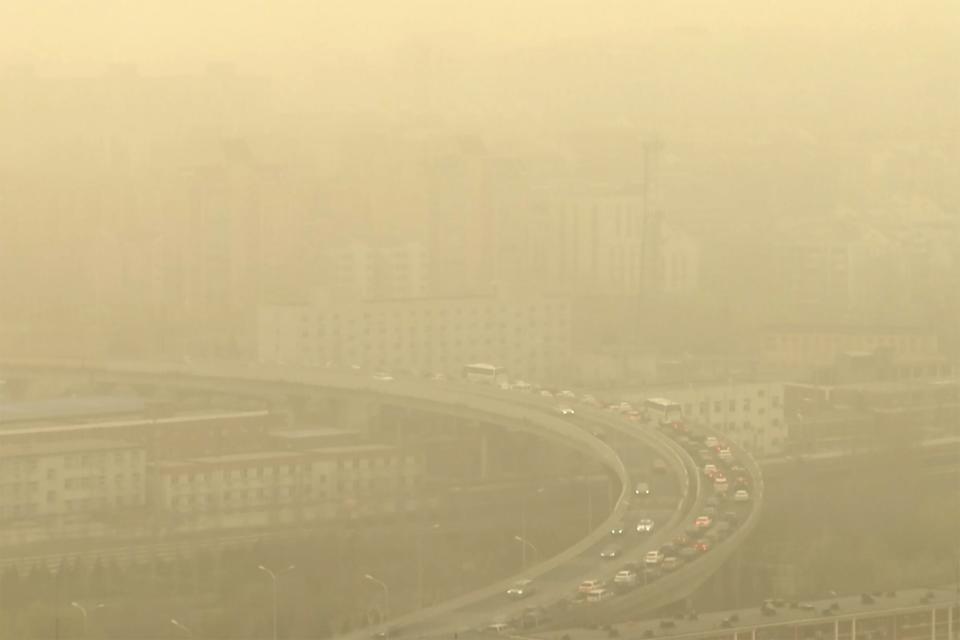 FILE - Cars drive along a highway shot through a glass window during a dust storm amid heavy pollution in Beijing, March 10, 2023. The United Nations Environment Assembly is meeting in Nairobi on Monday, Feb. 26, to discuss how countries can work together to tackle environmental crises like climate change, pollution and loss of biodiversity. (AP Photo/Borg Wong, File)