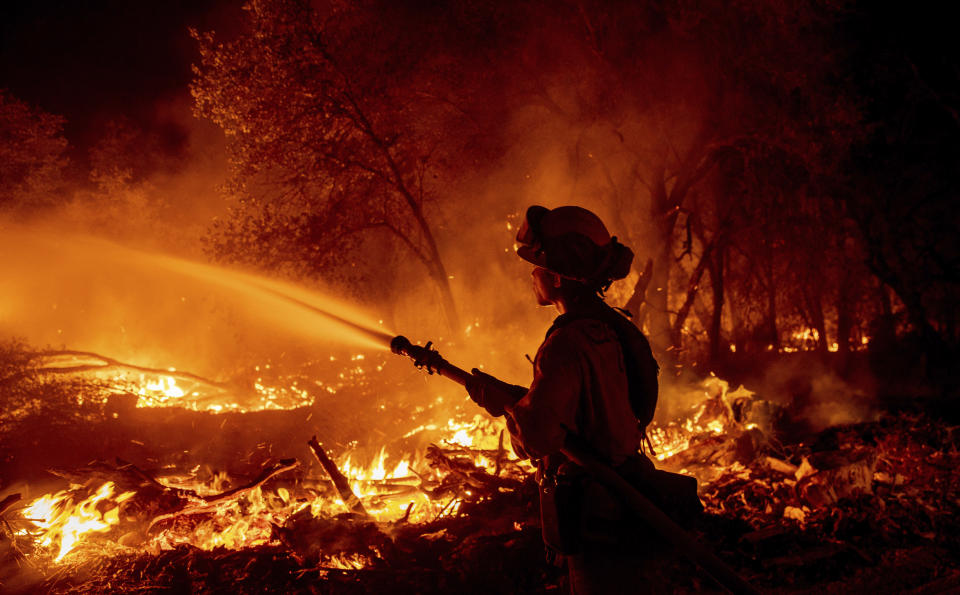 Firefighter Ron Burias battles the Fawn Fire as it spreads north of Redding, Calif. in Shasta County, on Thursday, Sept. 23, 2021. (AP Photo/Ethan Swope)