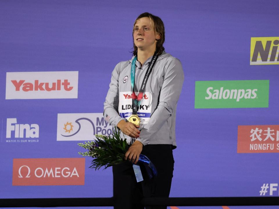 Katie Ledecky poses with her gold medal from 2022 FINA World Championships.