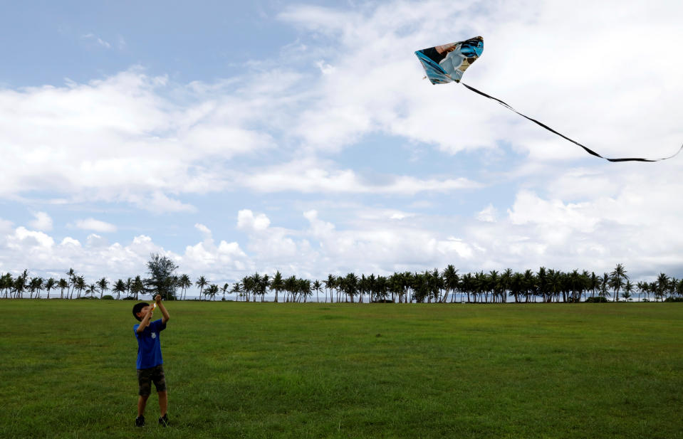 <p>A pupil flies his kite on the fields of Asan Memorial Park on the island of Guam, a U.S. Pacific Territory, August 11, 2017. (Erik De Castro/Reuters) </p>