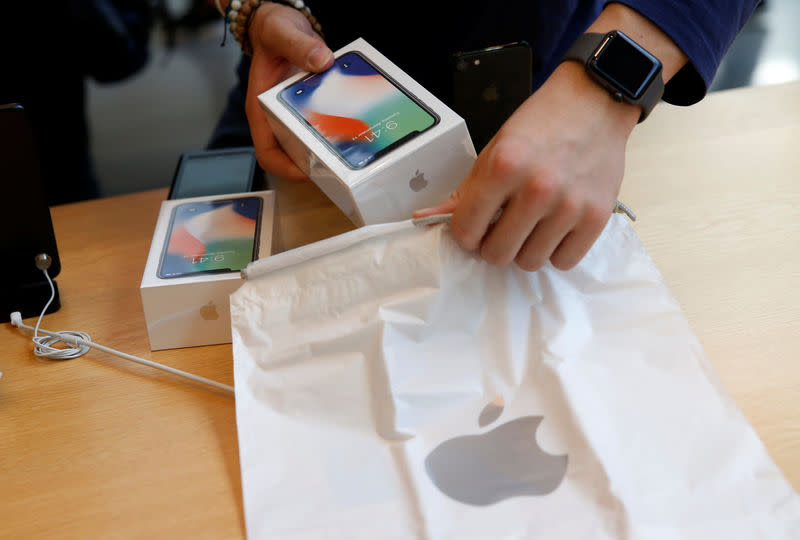 An Apple Store staff prepares to sell Apple’s new iPhone X after it goes on sale at the Apple Store in Tokyo’s Omotesando shopping district