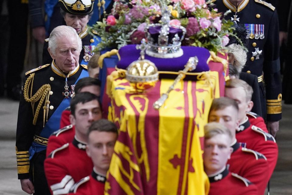 King Charles III and members of the royal family follow behind the coffin of Queen Elizabeth II, draped in the Royal Standard with the Imperial State Crown and the Sovereign’s orb and sceptre, as it is carried out of Westminster Abbey (PA) (PA Wire)