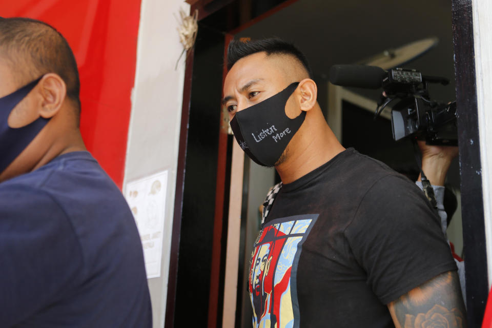 Australian national William Cabantog, right, is escorted by an Indonesian prison guard as he leaves Kerobokan prison in Bali, Indonesia on Saturday, July 25, 2020. Cabantog is released from the prison where he has served to twelve months. Cabantog and another man were arrested last July at the Lost City Club on Indonesia's resort island of Bali with 1.12 grams of cocaine. (AP Photo/Firdia Lisnawati)