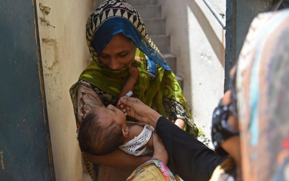 A health worker administers polio vaccine drops to a child during a door-to-door vaccination campaign in Karachi this week - Rizwan TABASSUM/AFP