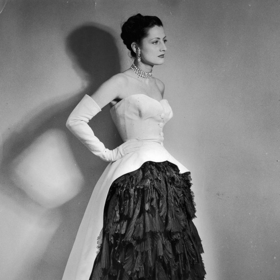 Woman in vintage strapless gown with tiered feather skirt and a pearl necklace