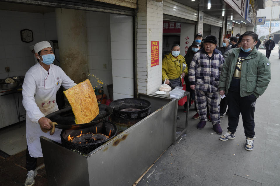 Residents wearing masks to help curb the spread of the coronavirus queue up at a popular food stall in Wuhan, China, Tuesday, Jan. 26, 2021. The central Chinese city of Wuhan, where the coronavirus was first detected, has largely returned to normal but is on heightened alert against a resurgence as China battles outbreaks elsewhere in the country. (AP Photo/Ng Han Guan)