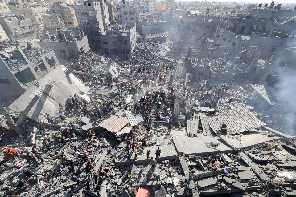 People search for survivors and the bodies of victims through the rubble of buildings destroyed during Israeli bombardment, in Khan Yunis in the southern Gaza Strip on October 26, 2023, amid the ongoing battles between Israel and the Palestinian group Hamas.