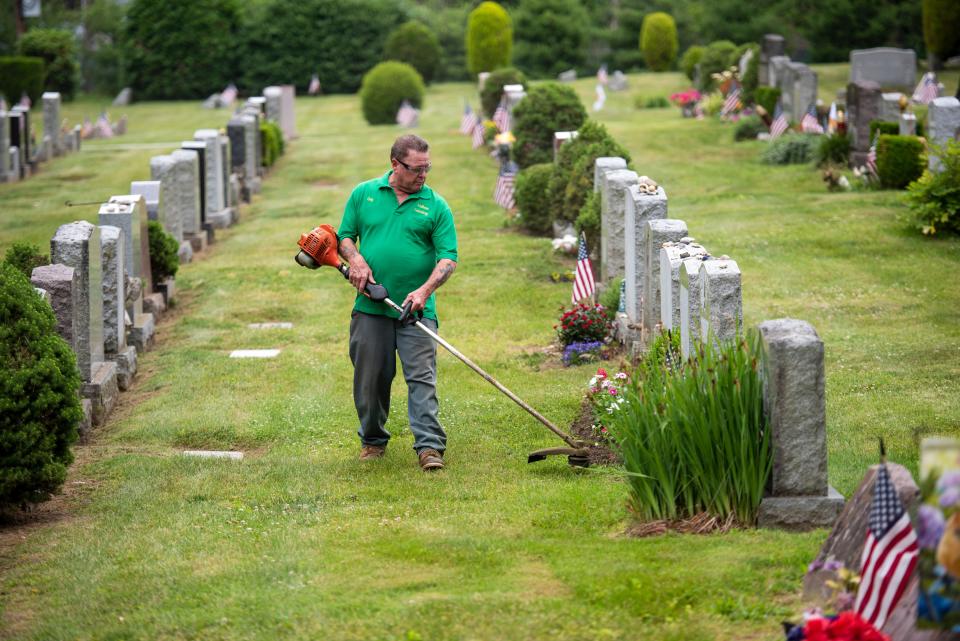 Guy Kostka trims grass and weeds at Valleau Cemetery in Ridgewood on Wednesday, June 22, 2022. Kostka is retiring as superintendent of Valleau Cemetery at the end of the month. 