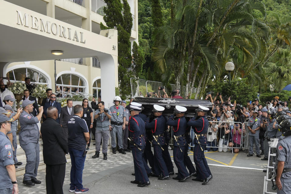 The remains of late Brazilian soccer great Pele are carried into Necropole Ecumenica Memorial Cemetery at the end of his funeral procession in Santos, Brazil, Tuesday, Jan. 3, 2023. (AP Photo/Andre Penner)