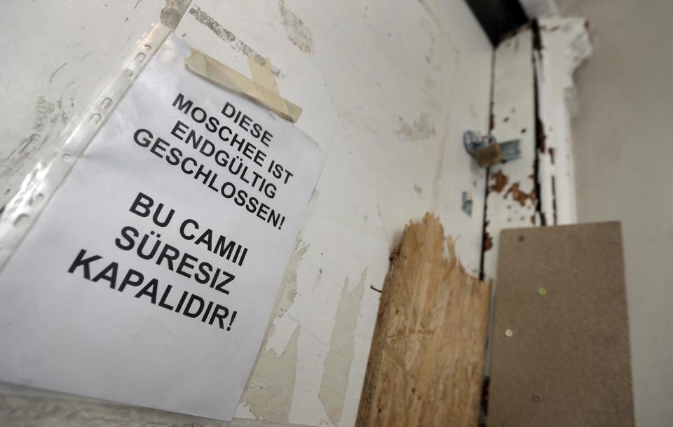 The entrance door of the closed Fussilet Mosque is pictured in Berlin, Germany, Tuesday, Feb. 28, 2017. German police are searching dozens of sites across Berlin linked to the mosque visited by the truck attacker Anis Amri. The raids follow a decision by state authorities on Tuesday to ban the organization that ran the mosque, Fussilet 33. German text reads 'This Mosque Is Finally Closed'. (AP Photo/Michael Sohn)