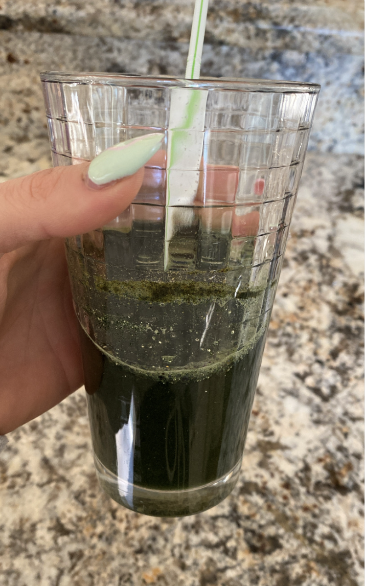 The green juice in a glass with a straw