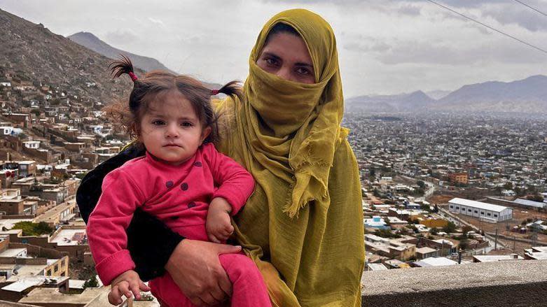 Sohaila Niyazi cargando a su hija y detrás se ve Kabul