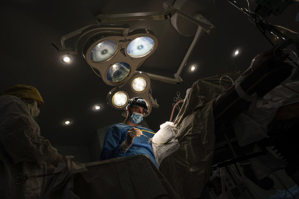 Neurosurgeon Nikita Lombrozo operates on a patient who sustained a shrapnel injury on the left part of the brain, at Mechnikov Hospital in Dnipro, Ukraine, Friday, July 14, 2023. A surge of wounded soldiers has coincided with the major counteroffensive Ukraine launched last month to try to recapture its land from Russian forces. Surgeons at Mechnikov Hospital, one of the country's biggest, are busier now than perhaps at any other time since Russia began its invasion 17 months ago. (AP Photo/Evgeniy Maloletka)