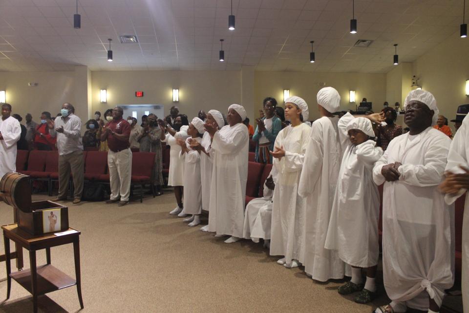 Parishioners waiting to be baptized (dressed in white) join others to praise God during praise and worship Sunday at the final worship service of the 15th anniversary celebration of Dr. Tyrone Blue as the pastor of First Missionary Baptist Church in SE Gainesville.
(Credit: Photo by Voleer Thomas/For The Guardian)