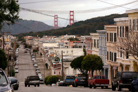 The Golden Gate Bridge rises above a neighborhood of tightly packed homes in the Richmond District in San Francisco, California, U.S. on March 27, 2012. REUTERS/Robert Galbraith/File Photo