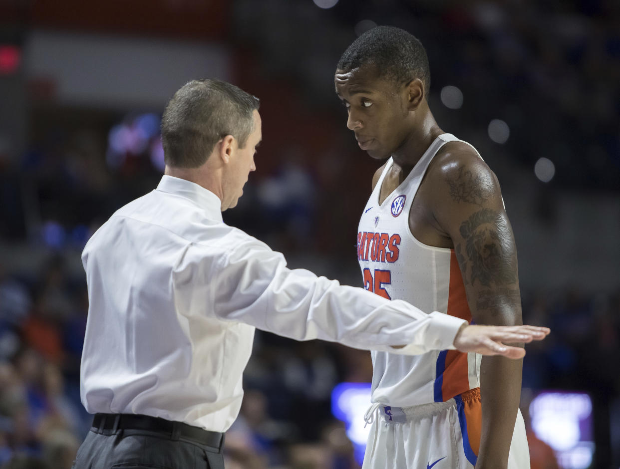 Florida head coach Mike White talks with forward Keith Stone (25) during the second half of an NCAA college basketball game against Loyola of Chicago in Gainesville, Fla., Wednesday, Dec. 6, 2017. Loyola of Chicago won 65-59. (AP Photo/Ron Irby)