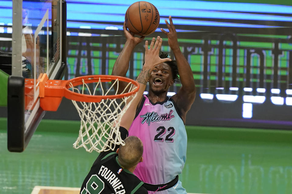 Miami Heat's Jimmy Butler (22) shoots at the basket as Boston Celtics' Evan Fournier (94) tries to block in the second half of a basketball game, Sunday, May 9, 2021, in Boston. (AP Photo/Steven Senne)
