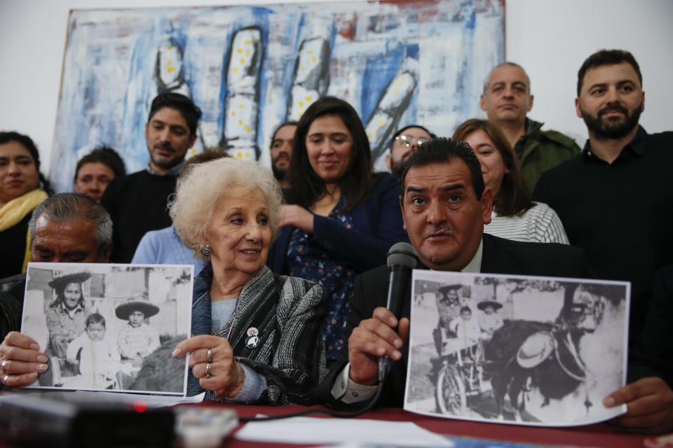 CORRECTS ISMAEL'S LAST NAME - Ismael Suleiman, right, talks beside President of the Grandmothers of Plaza de Mayo human rights group, Estela de Carlotto, as they hold pictures of Rosario del Carmen Ramos, with two of her three sons Ismael, right, and Camilo, before she disappeared during Argentina's military dictatorship, in Buenos Aires, Argentina Friday, Aug. 3, 2018. The human rights group announced they have found the son of Rosario, Marcos Eduardo Ramos, who was kidnapped together with his brother Ismael in 1976 during the last military dictatorship in Argentina. (AP Photo/Natacha Pisarenko)