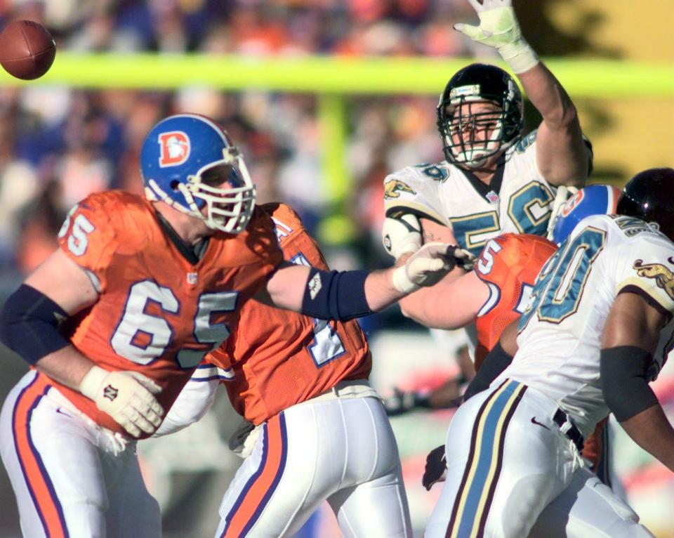 Jacksonville Jaguars defensive ends Jeff Lageman, arm up, and Tony Brackens, right, apply pressure as Denver Broncos quarterback John Elway (partially obscured by #65) releases the ball during the Jan. 4, 1997, playoffs.