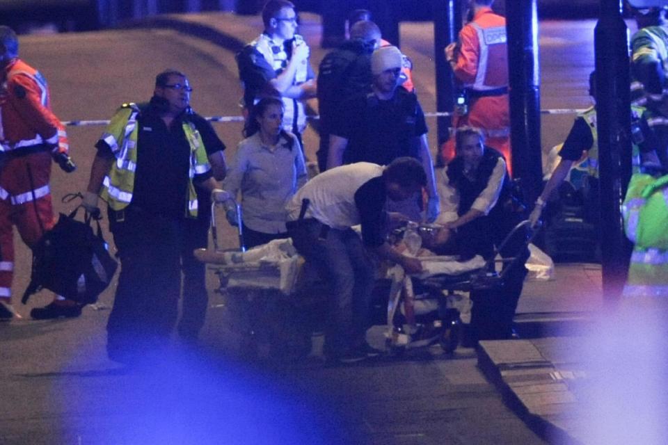 Police officers and members of the emergency services attend to a person injured. (Daniel Sorabji/AFP/Getty Images)