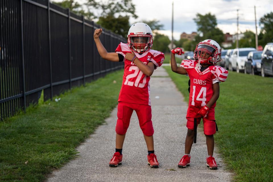 Amir Jones, left, of Detroit, and his cousin Eric Jones, of Detroit, show their muscles while arriving to a practice for the West Side Cubs at McCabe Field in Detroit on Tuesday, Sept. 12, 2023. More than just youth football and cheerleading teams, the West Side Cubs represent a vital community institution with a 66-year history.