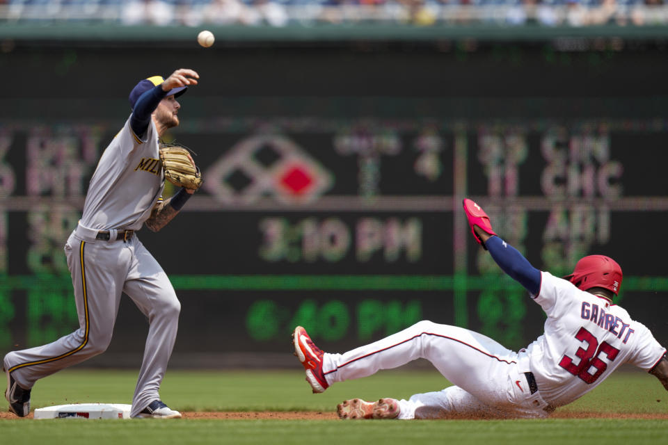 Washington Nationals' Stone Garrett is out at second base as Milwaukee Brewers second baseman Brice Turang throws to first base to complete the double play on Riley Adams during the second inning of a baseball game at Nationals Park, Wednesday, Aug. 2, 2023, in Washington. (AP Photo/Alex Brandon)