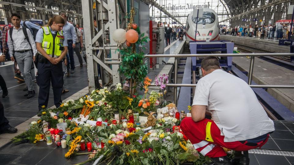 Ein Ersthelfer, der am Tag zuvor vor Ort war, legt am Bahnsteig 7 im Frankfurter Hauptbahnhof Blumen nieder. Foto: Frank Rumpenhorst